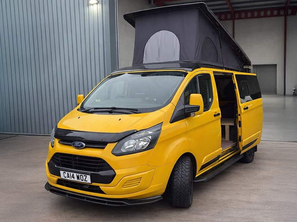 Yellow Ford Transit campervan conversion with pop top roof